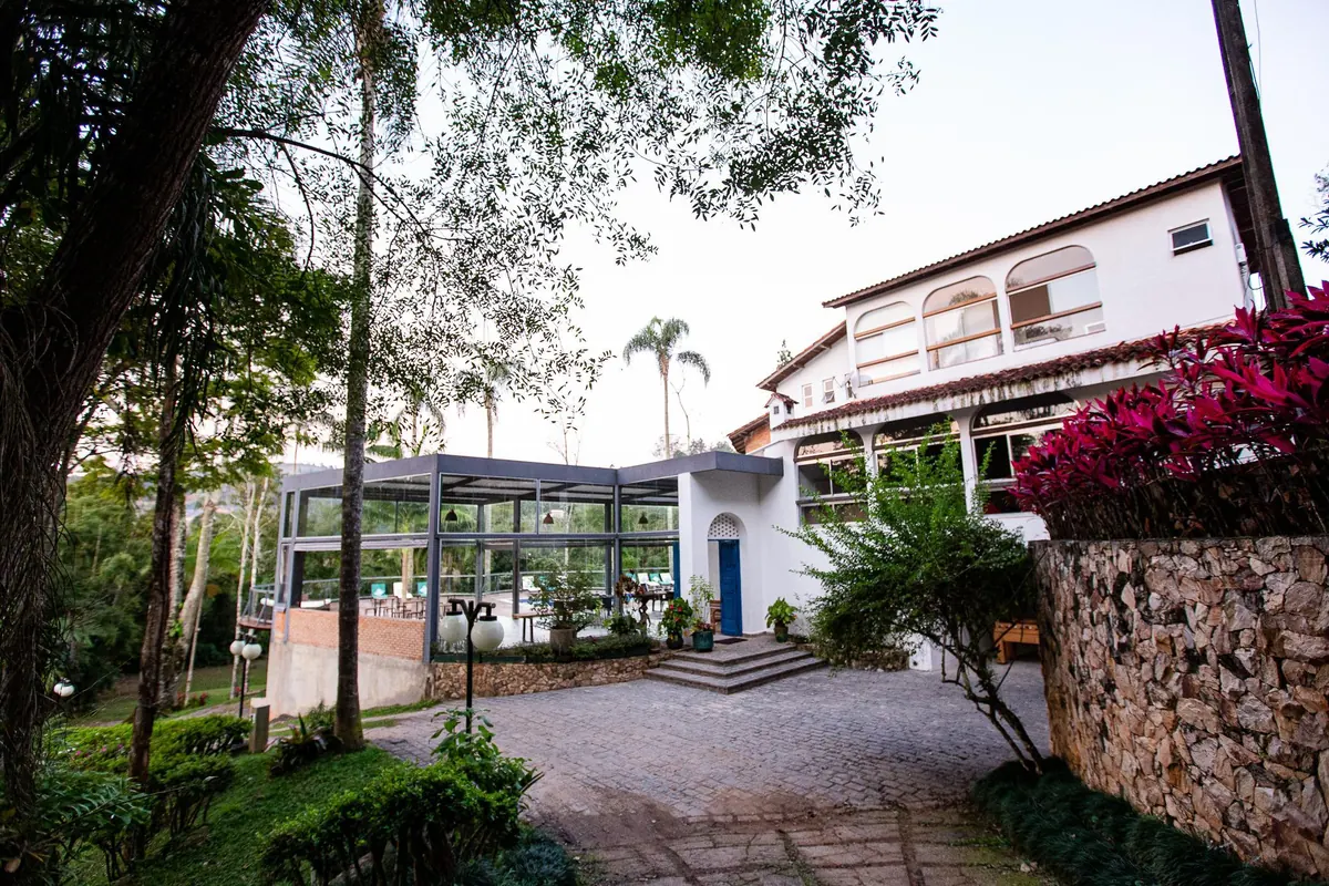 A casa principal e o salão coberto vistos da entrada